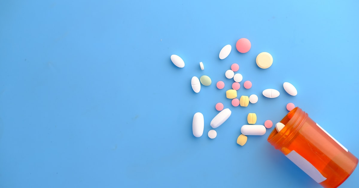 Supplement capsules and tablets arranged near an amber bottle representing functional medicine protocol management